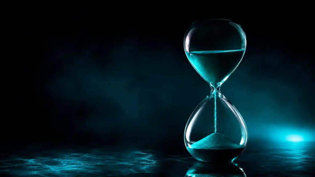 An hourglass with teal sand on a dark reflective surface, representing Skrill casino withdrawal times